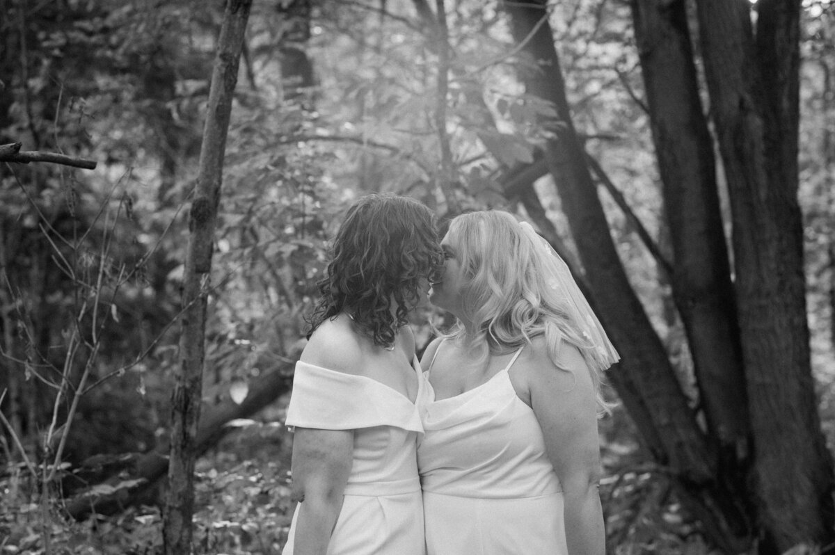 brides kissing in forest