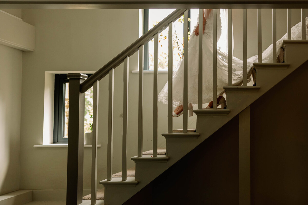 Bride walking down stairs at home before leaving for her Leeds Wedding Ceremony
