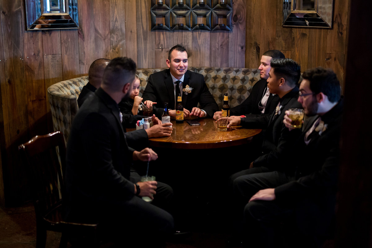 groom and groomsmen have a drink before wedding ceremony in Texas Hill Country wedding