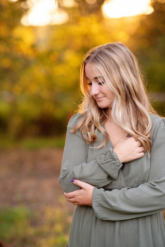 Senior session of young woman wearing a sage green dress