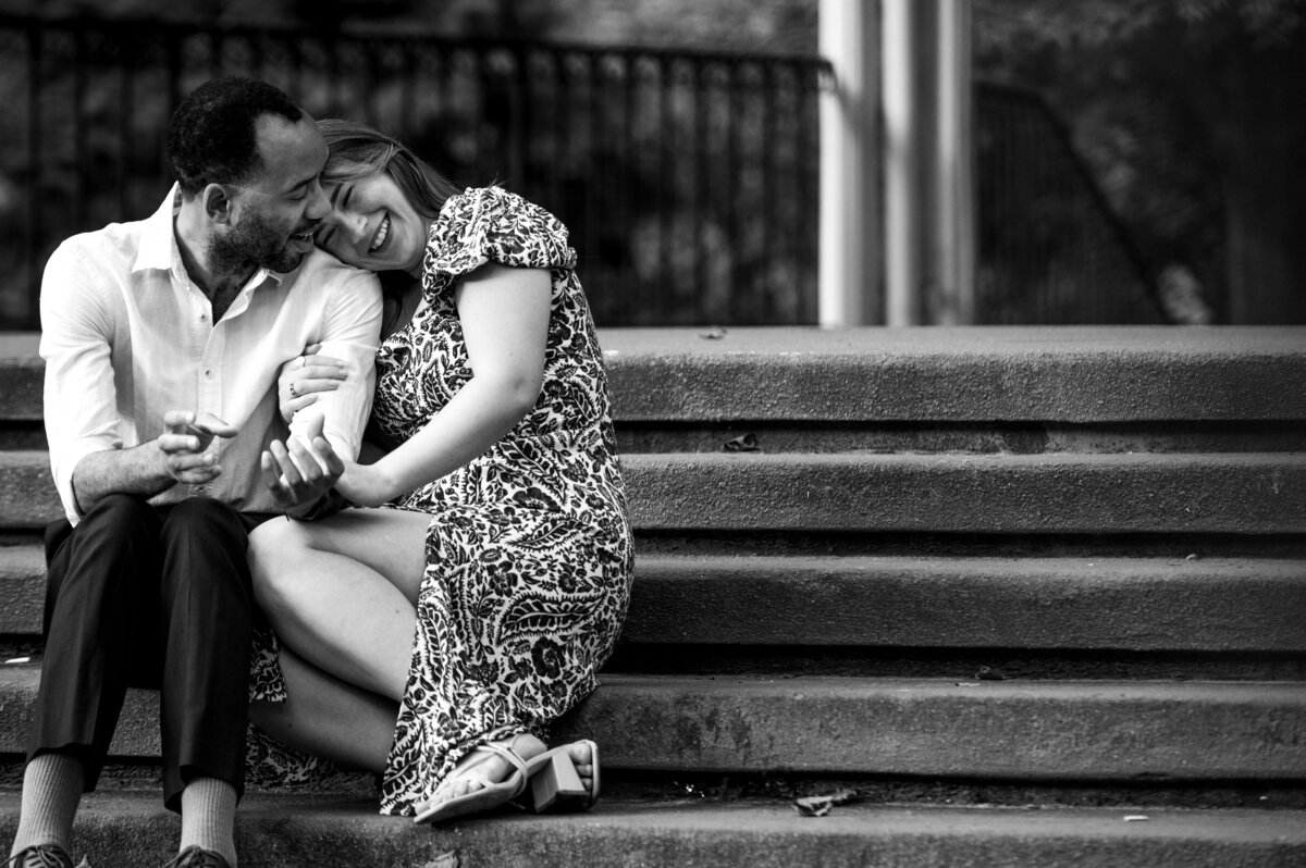 Black and white photo of a couple sitting on steps.