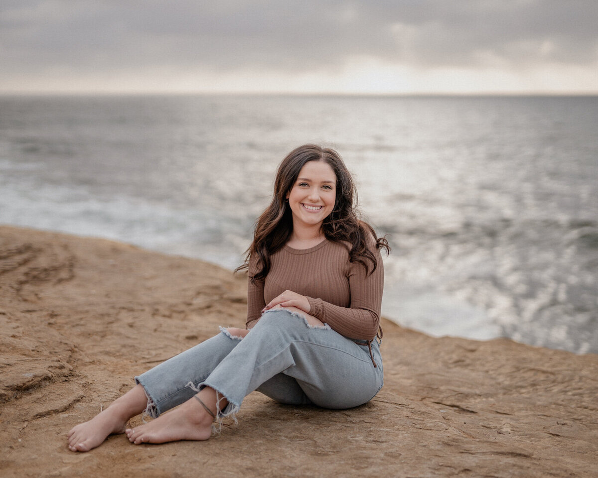 Girl sitting on beach for Senior Photos in Sunset Cliffs San Diego California
