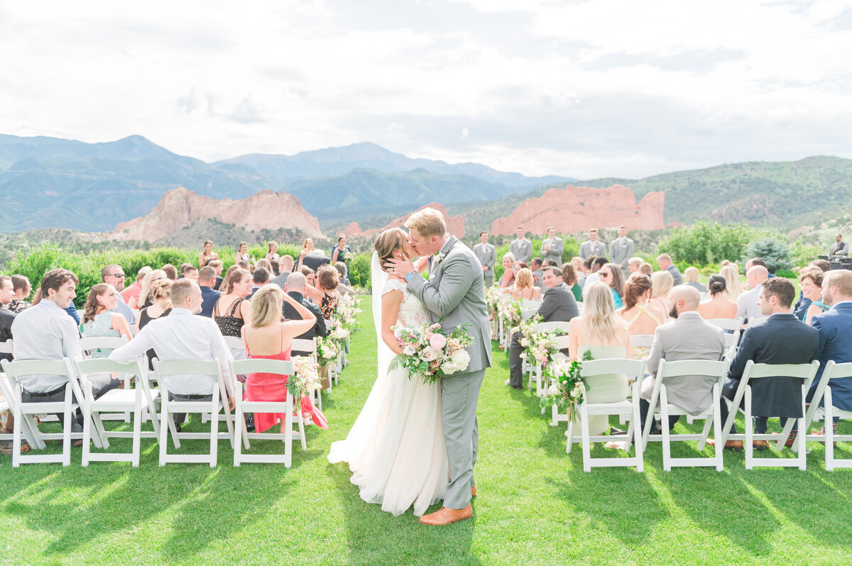 A ceremony exit kiss for the bride and groom at Garden of the Gods Resort and Club.