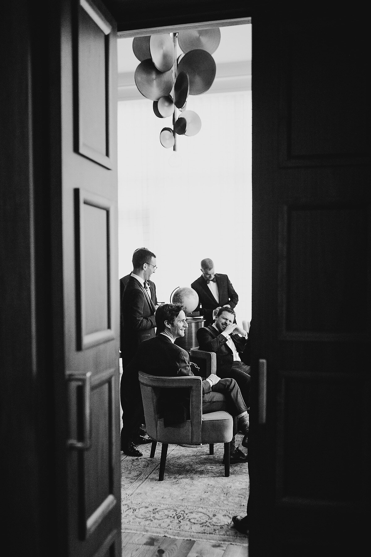 Groom and groomsmen before wedding sitting and speaking.