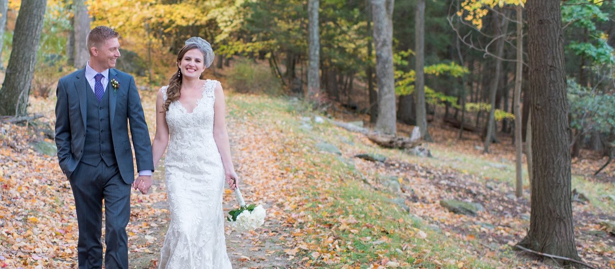 Bride and Groom Laughing while Walking through a Forest during the Fall at Sedgewood Country Club in Carmel, New York Photo