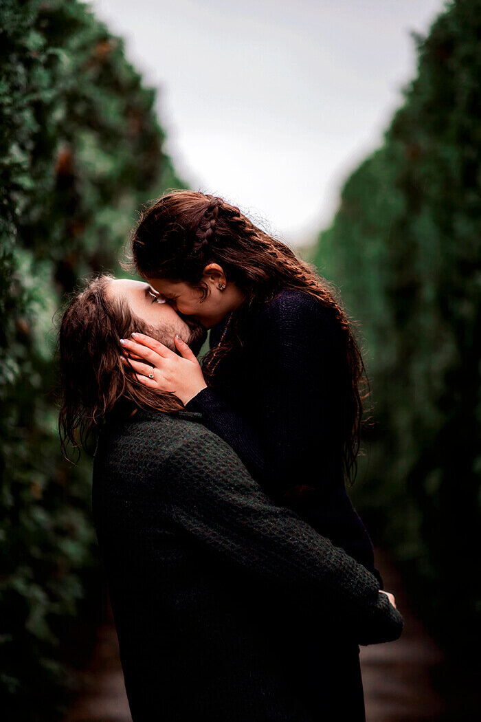 man-and-woman-kiss-in-row-of-trees