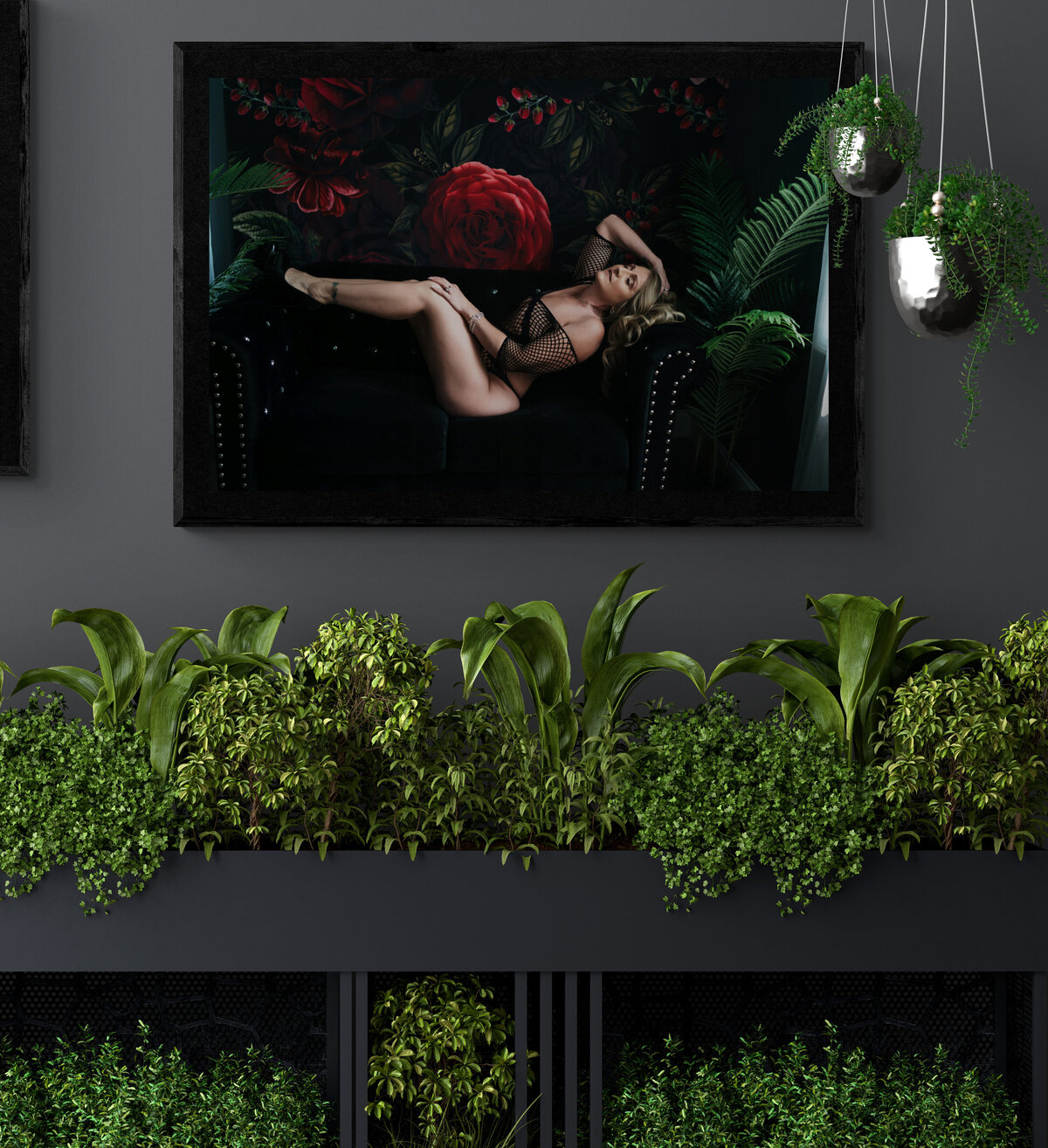 Artwork of a woman in black mesh lingerie hanging on a wall surrounded by indoor house plants