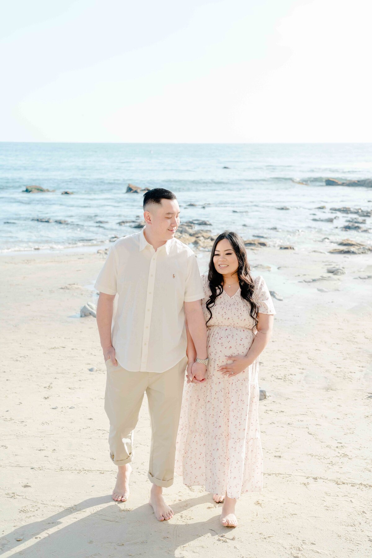 Soon to be parents at beach photoshoot with neutral colored outfits