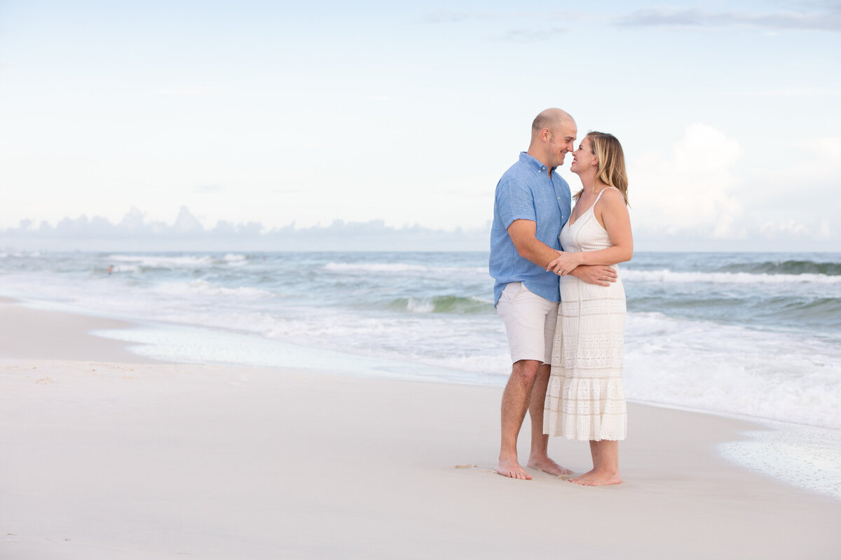 A couple kissing while standing along the water