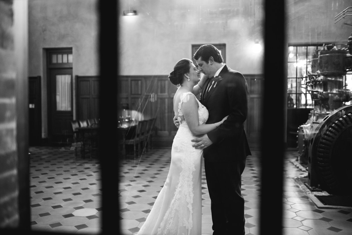 bride and groom about to kiss through a window at Hotel Emma wedding venue at the Historic Pearl Brewery in San Antonio