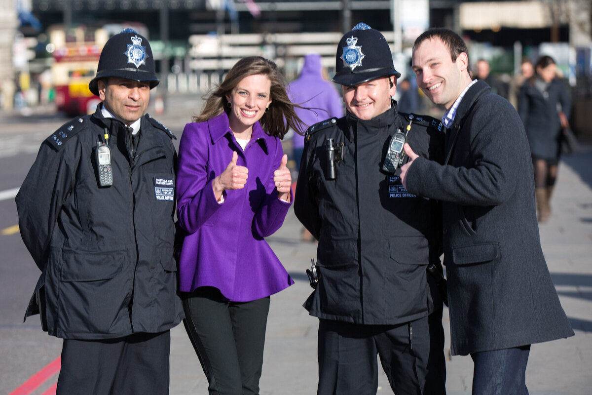 Woman in purple giving a thumbs up with officers