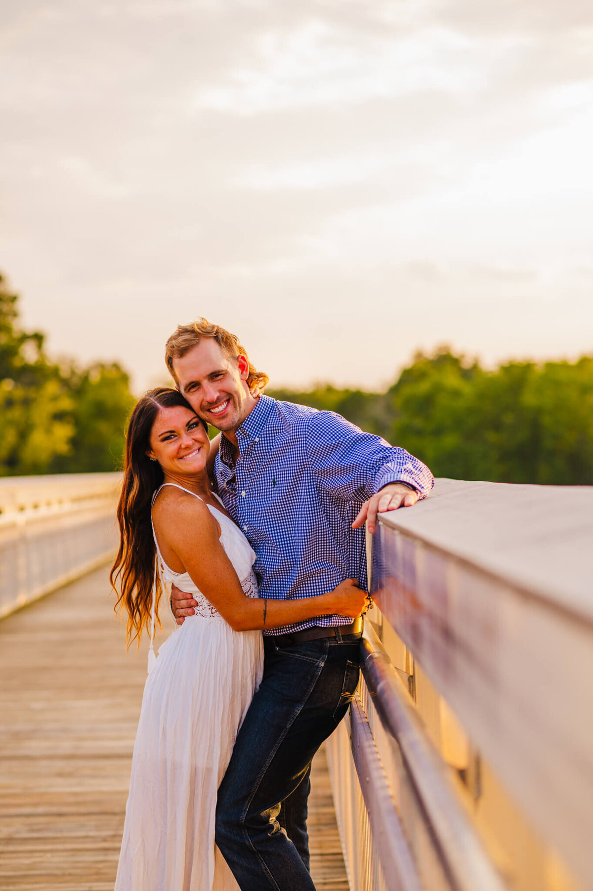 photo of a man and woman hugging and smiling on a white bridge