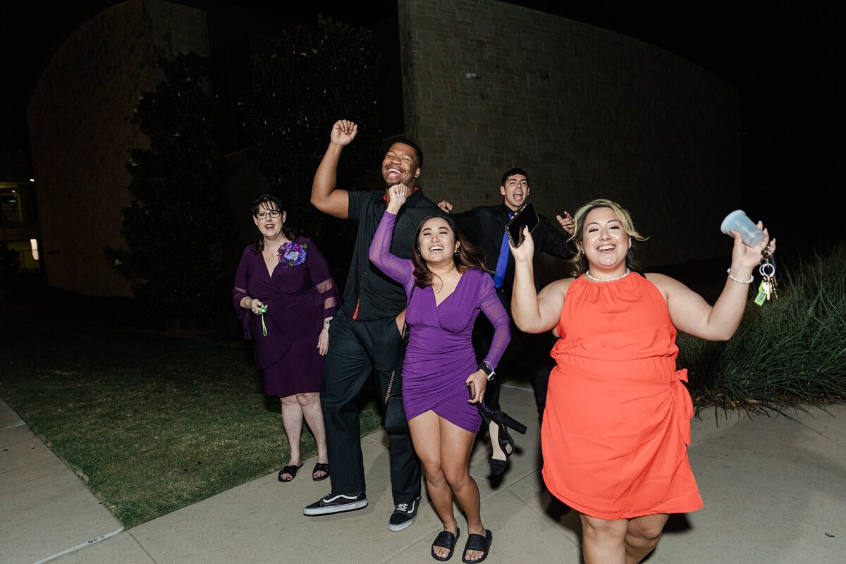 Multiple wedding guests cheering and getting lined up for the couples' exit from a wedding reception in Fort Worth, Texas.