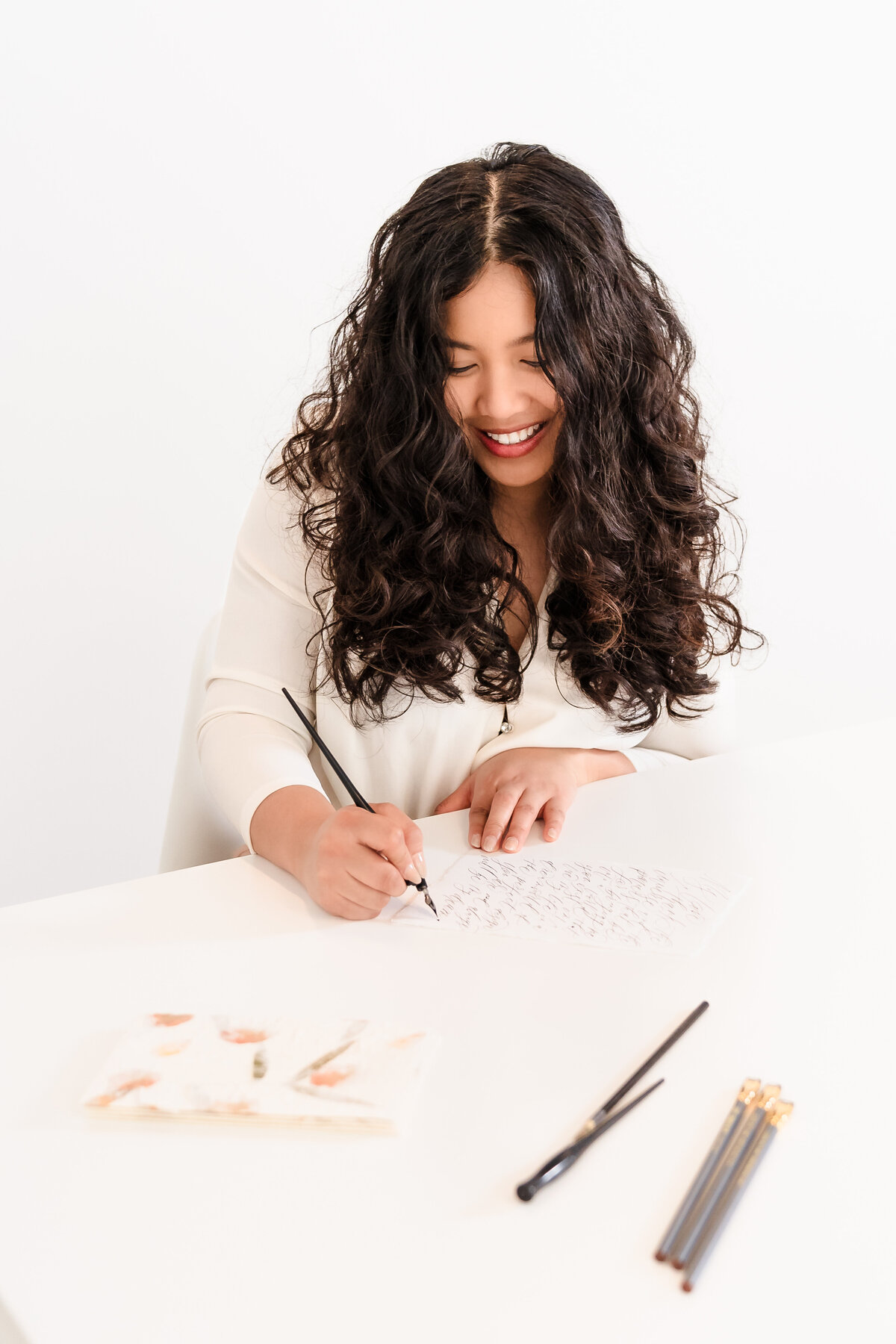 brand photo of a calligrapher with a pen in her hands