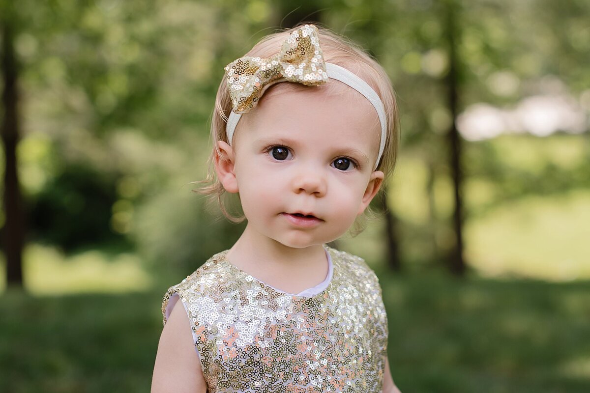 toddler flower girl with gold sparkly top and big bow m