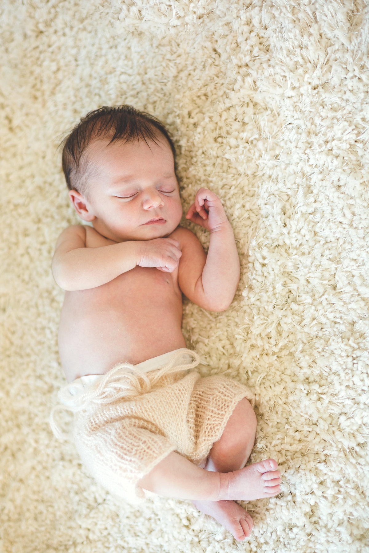 Sleeping newborn on soft neutral carpet