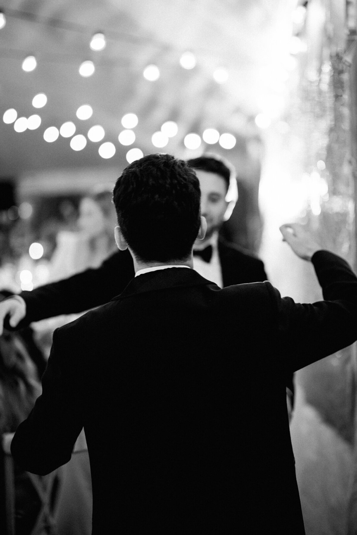 Black and white photo of the groom hugging his best man at Longboat Key Club.
