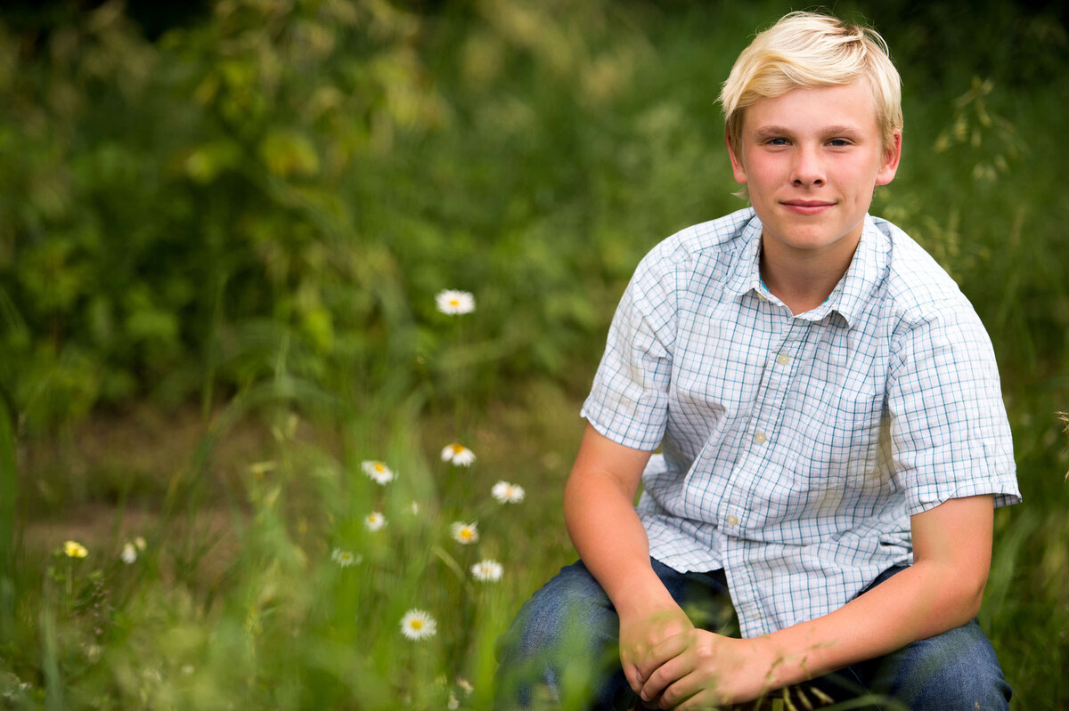 family photography in Ottawa of a young teen boy in a field with his family