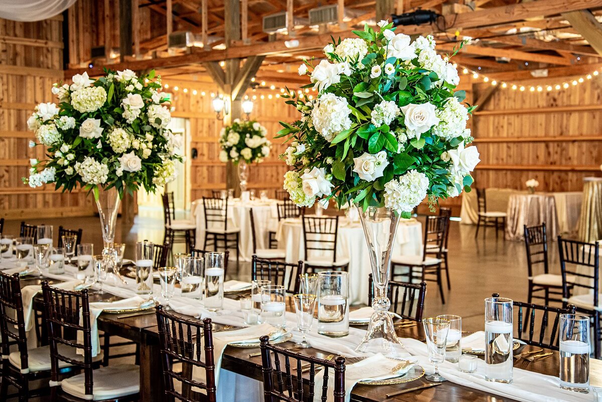 Luxury tall wedding centerpieces designed on clear trumpet vases
