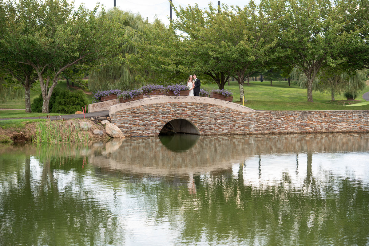distant photo of bride and groom on bridge at golf course at Willow Creek Golf and Country Club wedding