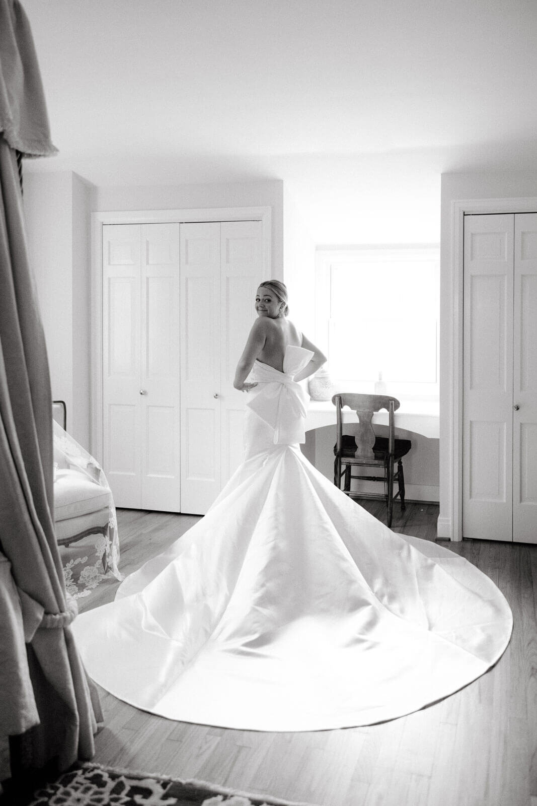 Back view of the bride in her gorgeous wedding dress inside a room at The Lion Rock Farm, CT. Image by Jenny Fu Studio