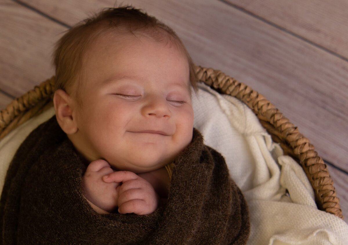 Newborn baby smiling through a dream