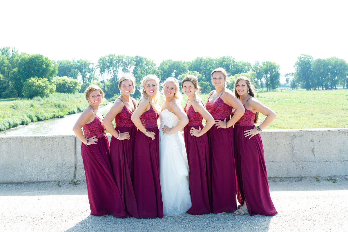 Bride and bridesmaids pose in front of beautiful Nebraska creek after wedding