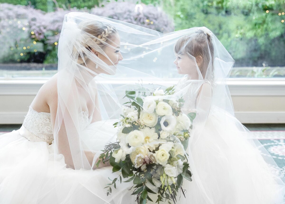 Bride and flower girl under veil