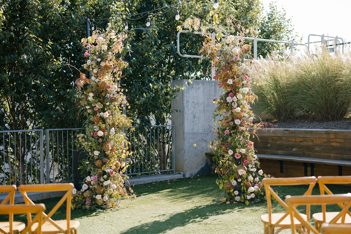 Broken Arch Ceremony Backdrop for fall Carolina’s wedding in Raleigh. Floral colors in mauve, cream, dusty pink, dusty blue, copper, and natural green. Floral accents of roses and fall color branches. Design by Rosemary and Finch Floral Design based out of Nashville, TN.
