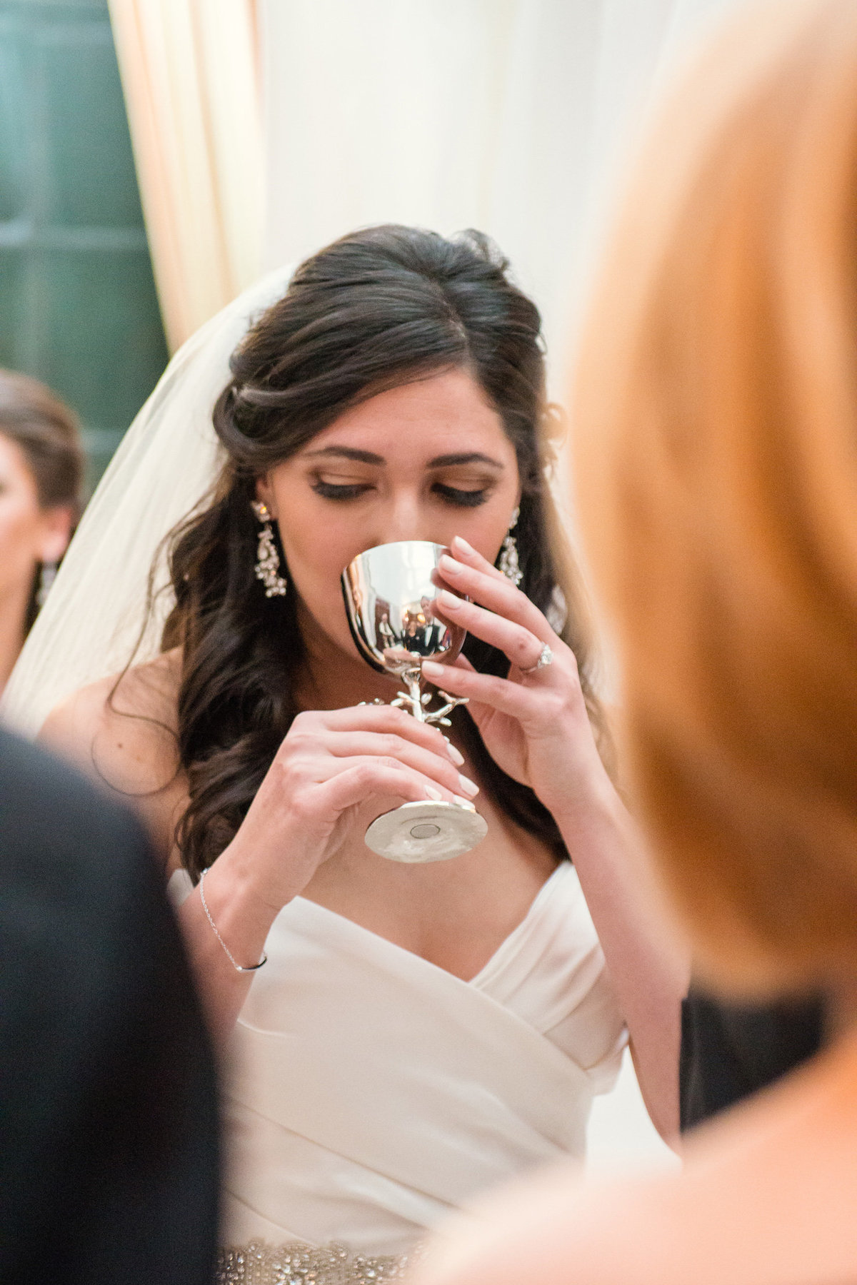Bride drinking from her wine glass during a wedding ceremony at The Bourne Mansion