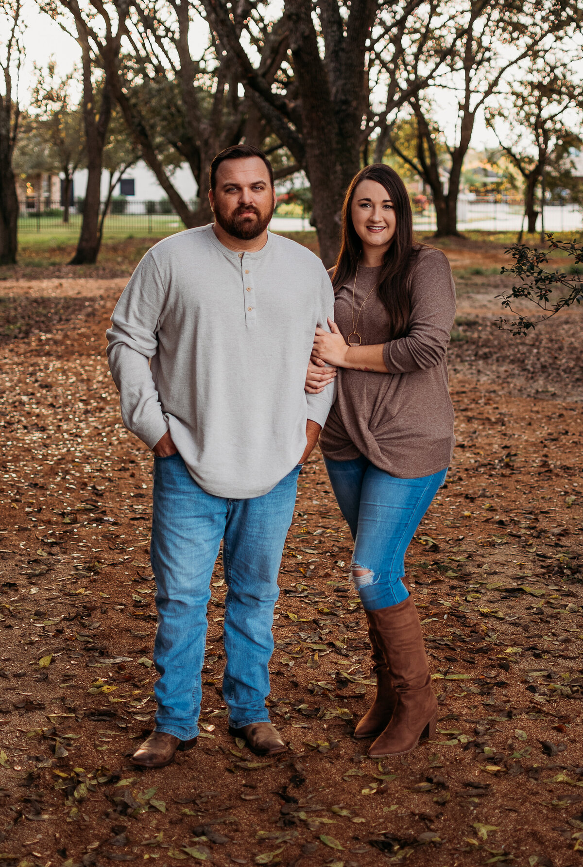 A married couple holds hands and smiles at the camera during an extended family session.