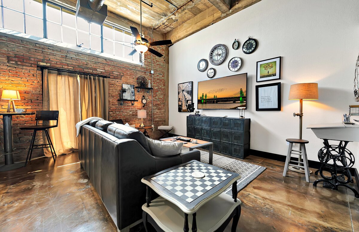 Living area with exposed brick and Smart TV at this two-bedroom, two-bathroom vacation rental condo in the historic Behrens building in the heart of the Magnolia Silo District in downtown Waco, TX.
