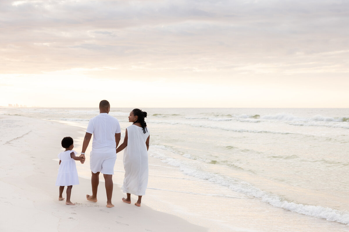 A family of three walking at the beach