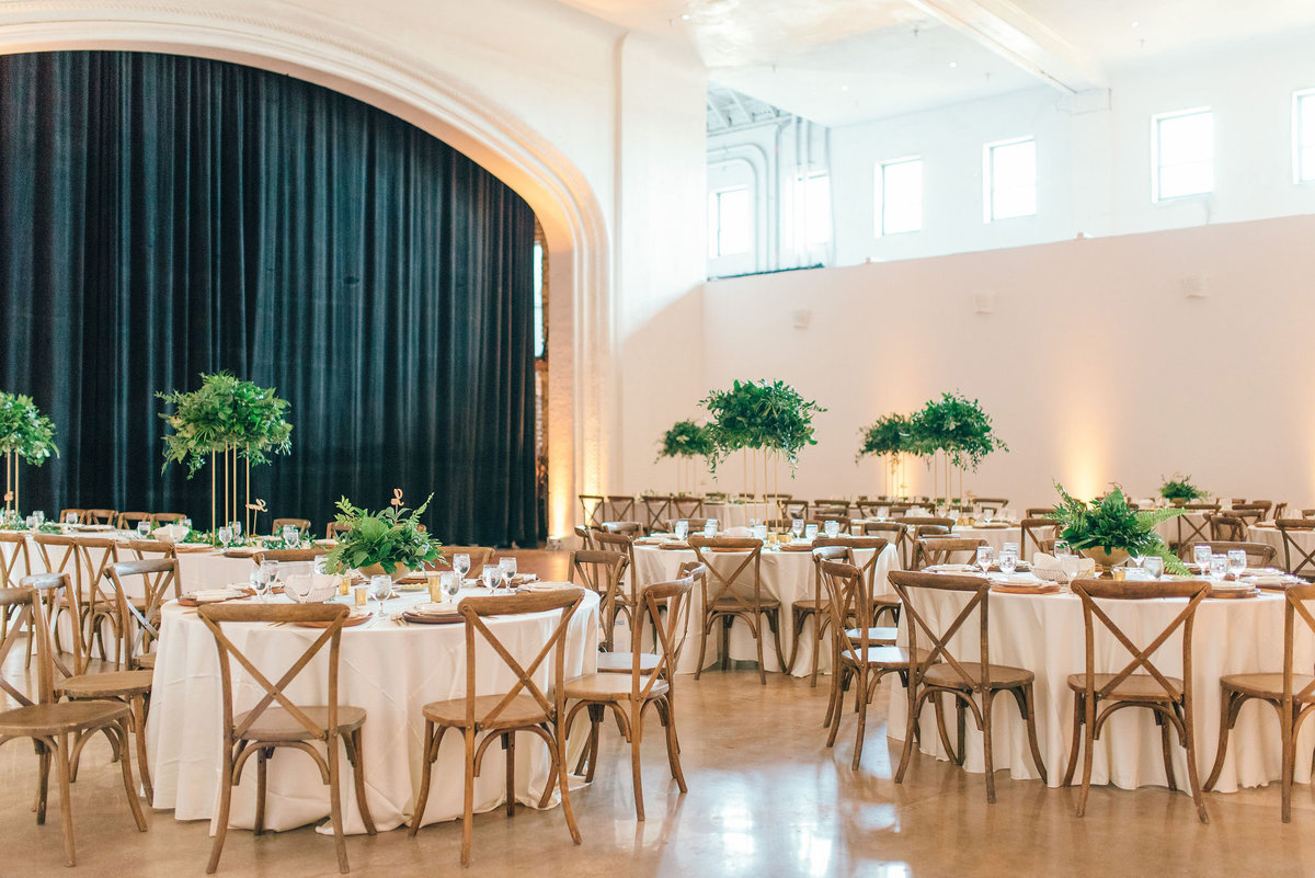 wood chairs with greenery tall centerpieces