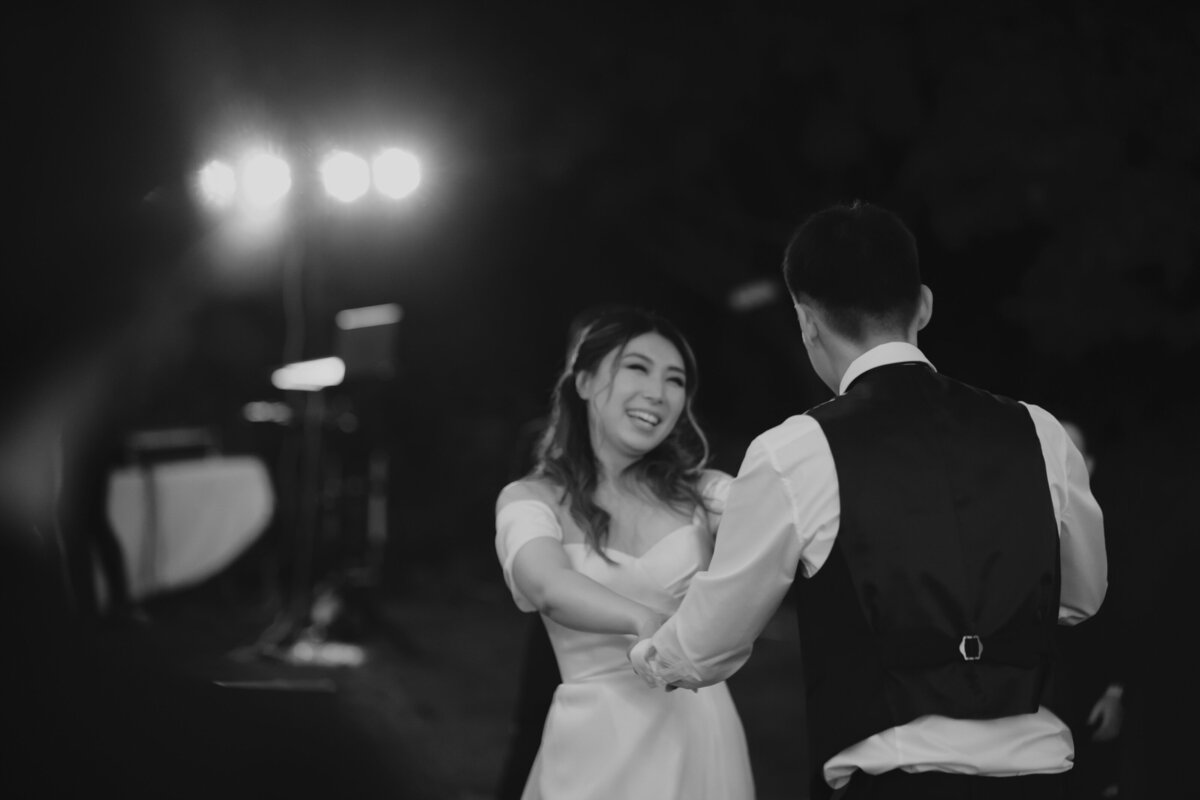 the bride smiling at her groom while dancing