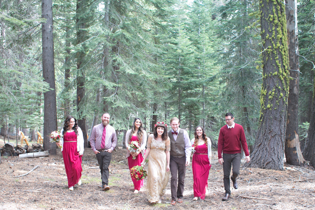 Bride, groom, and wedding party walking together in the Tahoe forest