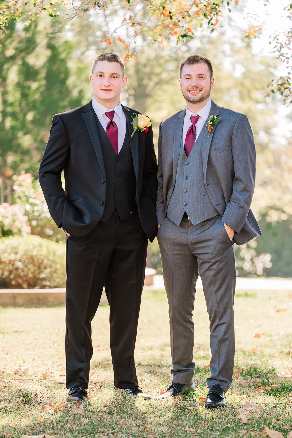 A groom in a black tux with one of his groomsmen in a grey tux during a fall wedding in Raleigh enjoying their North Carolina wedding photography
