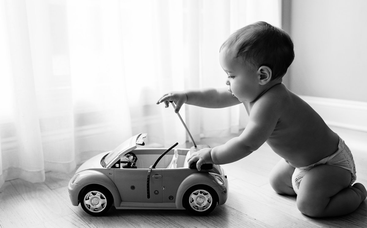 charlotte documentary photographer captures beautiful image of a toddler playing with his car next to a window