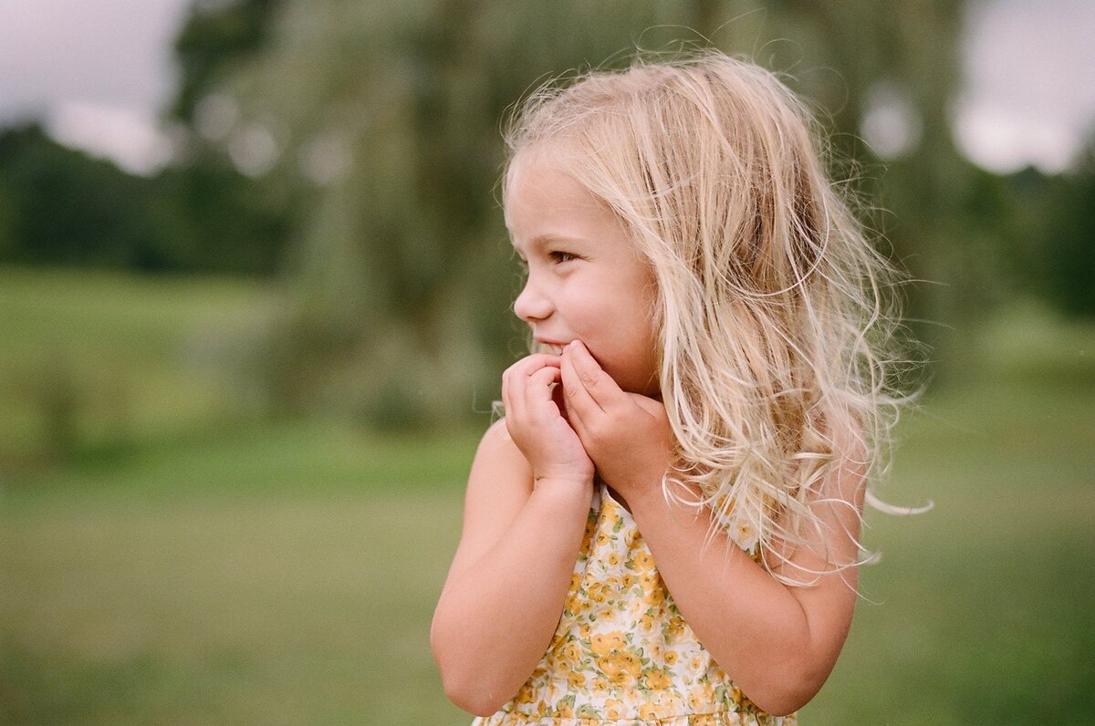 young blond girl in yellow dress giggling