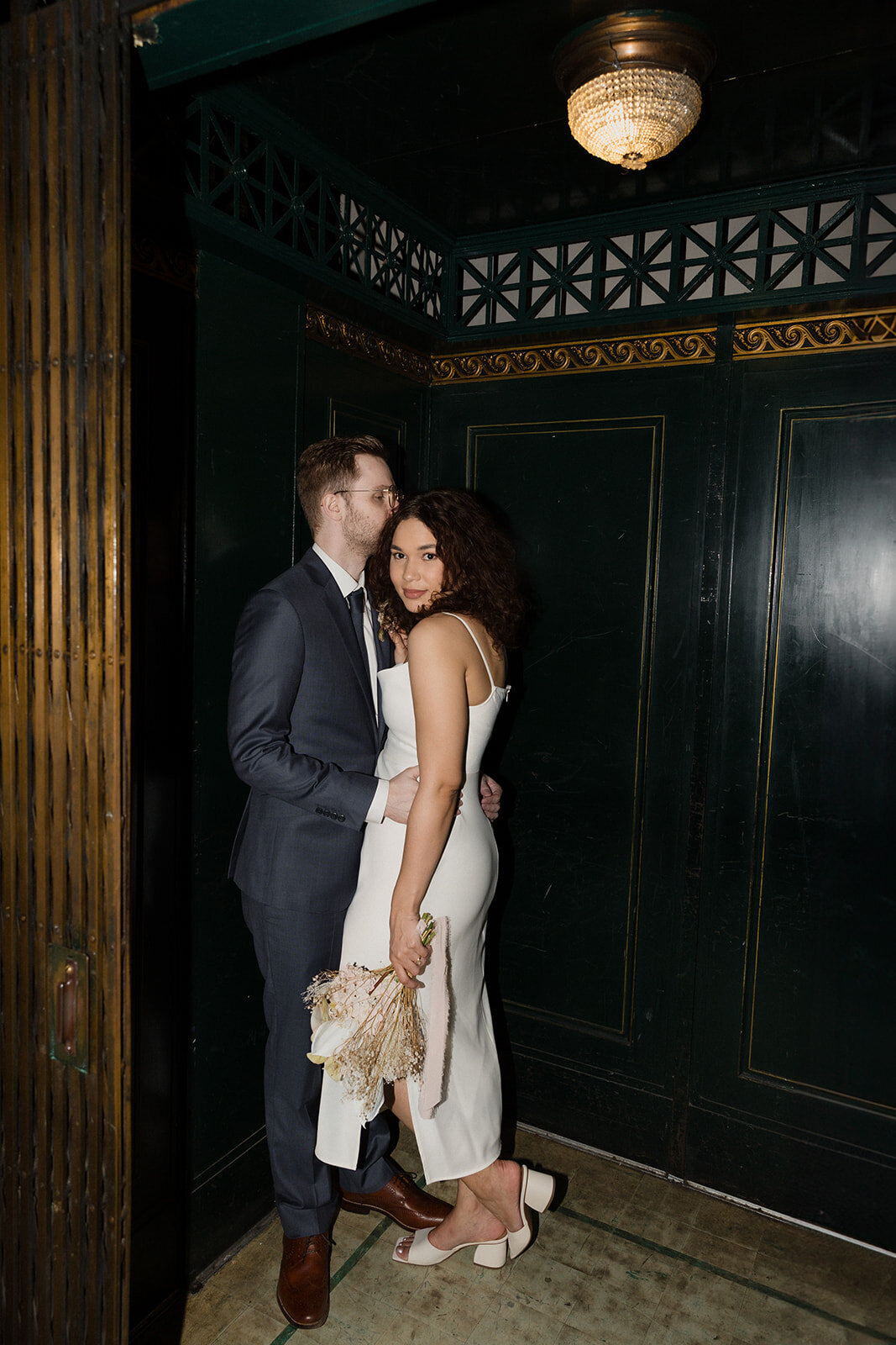 Just Married photo session couple kisses on dark old fashioned birdcage elevator at International Museum of Surgical Science.