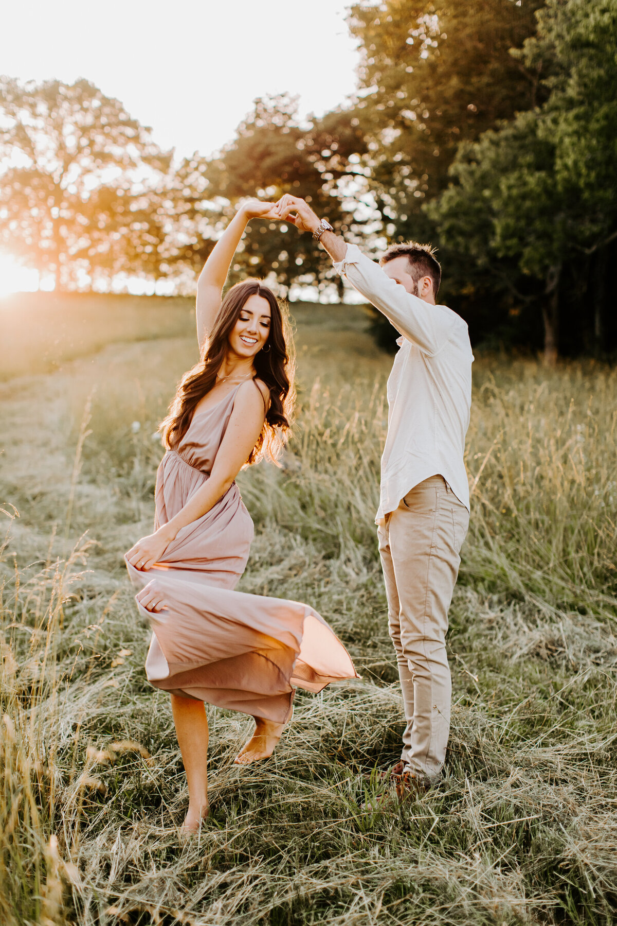 couple dancing in a field at golden hour