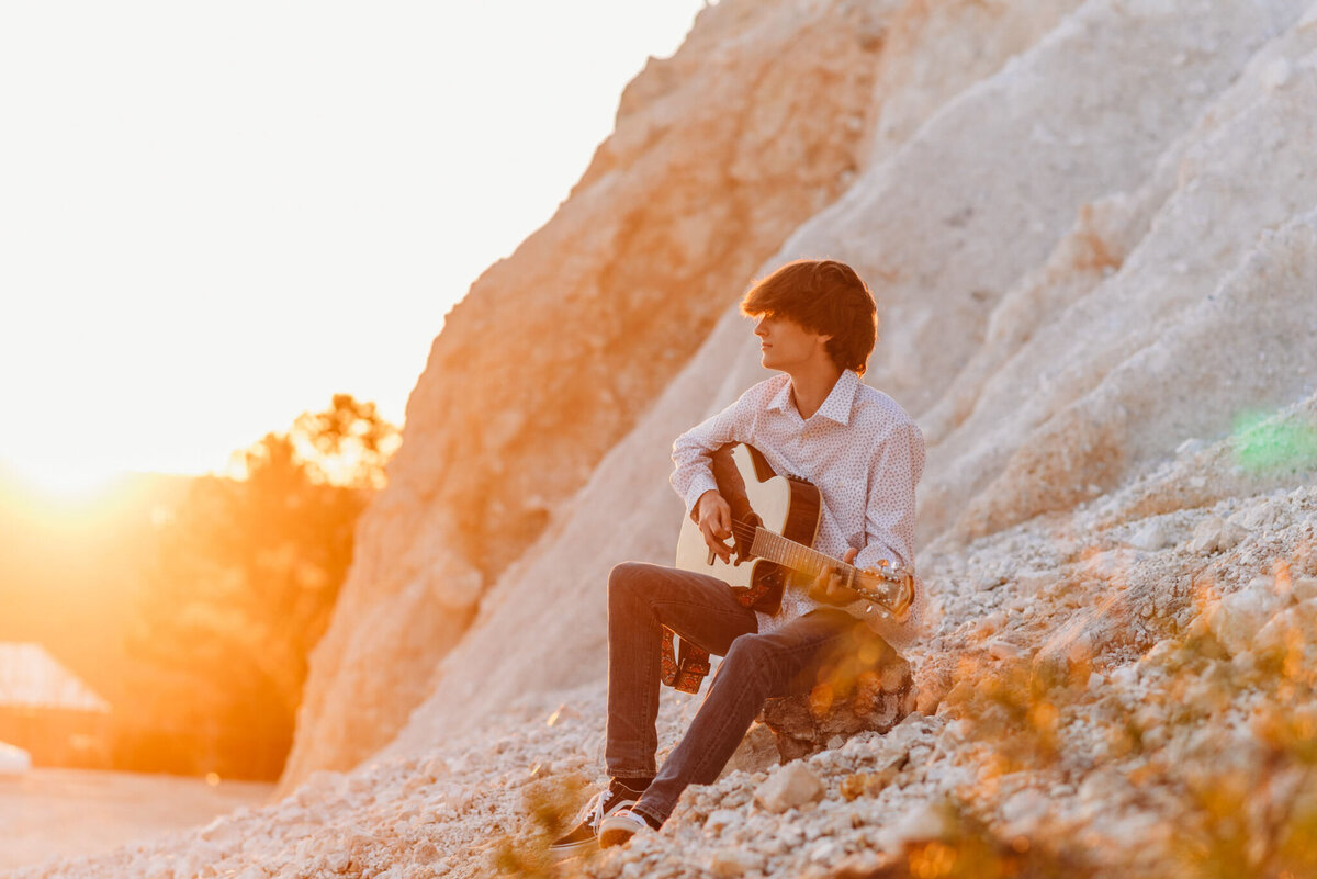 photo of a boy playing his guitar