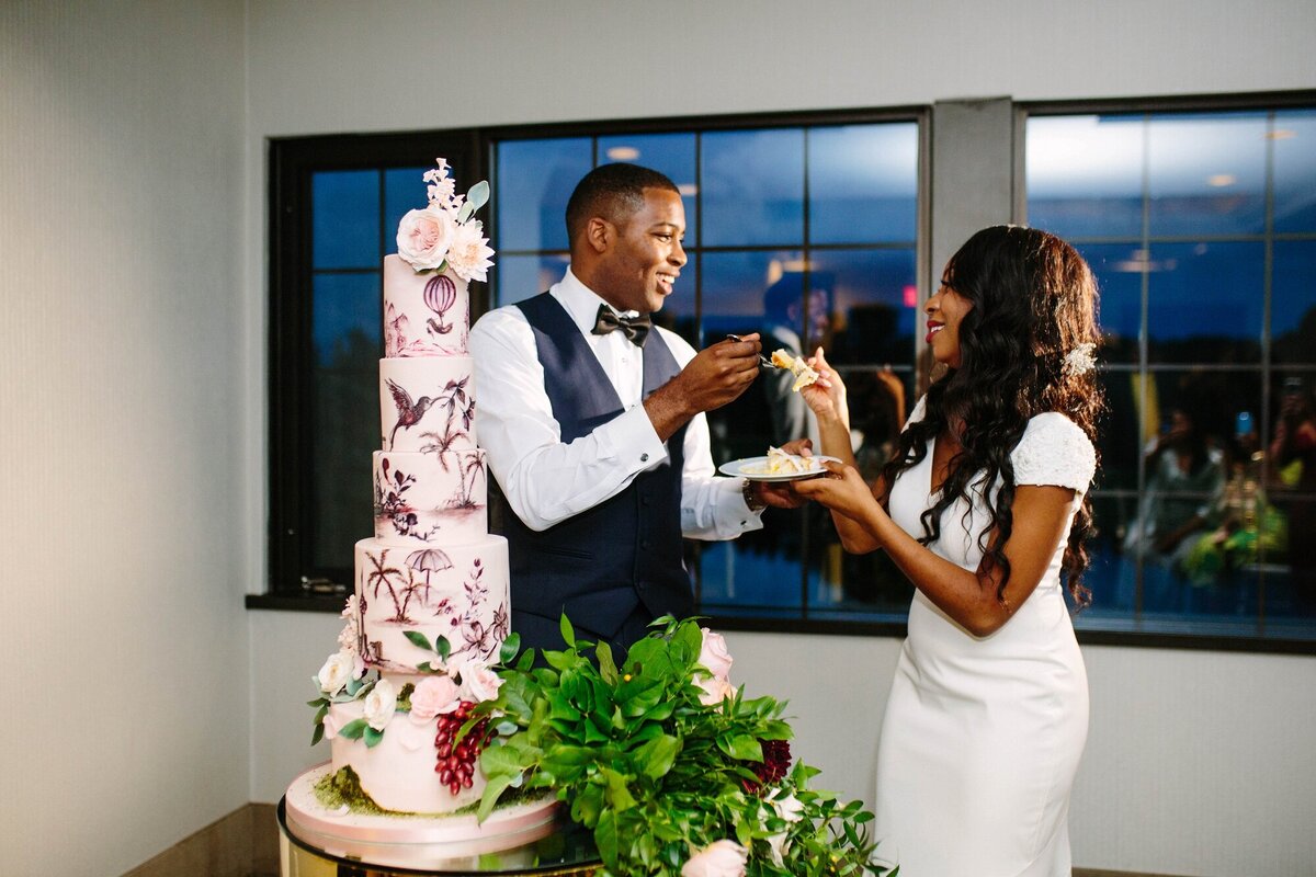 bride and groom feed wedding cake to each other at The Manor