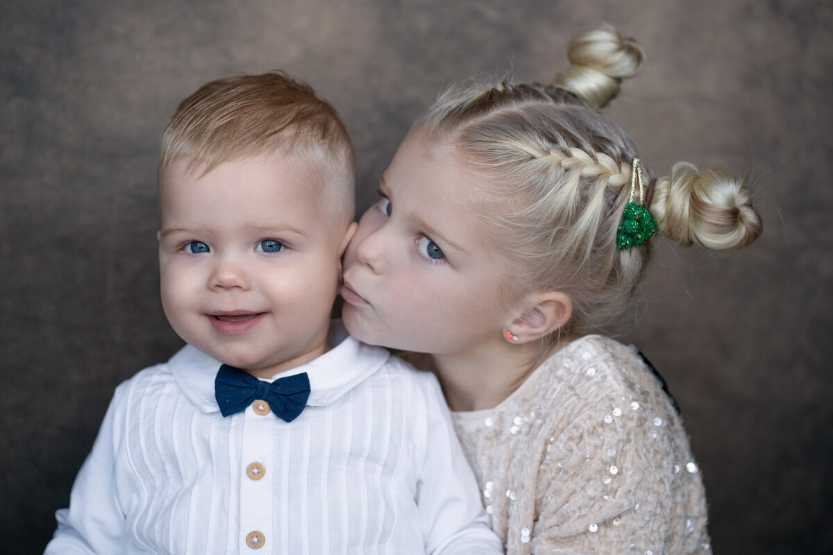 Deze afbeelding toont een ongedwongen familieshoot waarin een gezin zich volledig laat gaan in een natuurlijke omgeving. De sfeer is ontspannen en speels, met spontane lachende gezichten en liefdevolle interacties die de sterke band binnen het gezin weerspiegelen. Deze fotoshoot legt niet alleen mooie beelden vast, maar ook de pure emoties en het plezier van het samenzijn, wat zorgt voor tijdloze herinneringen