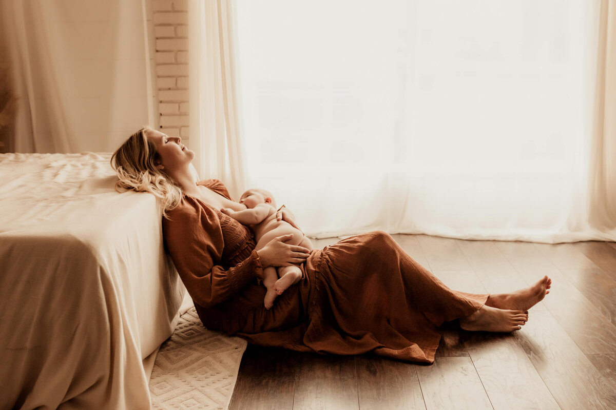 Breastfeeding photo of a mother and her son sitting on the floor in a studio in Tulsa, Oklahoma.