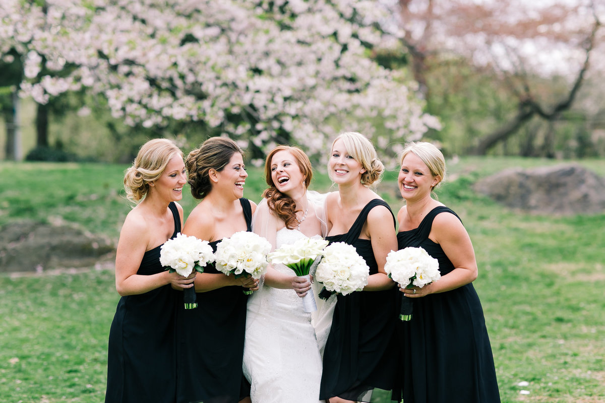 bridesmaids and bride laughing in a spring day in central park