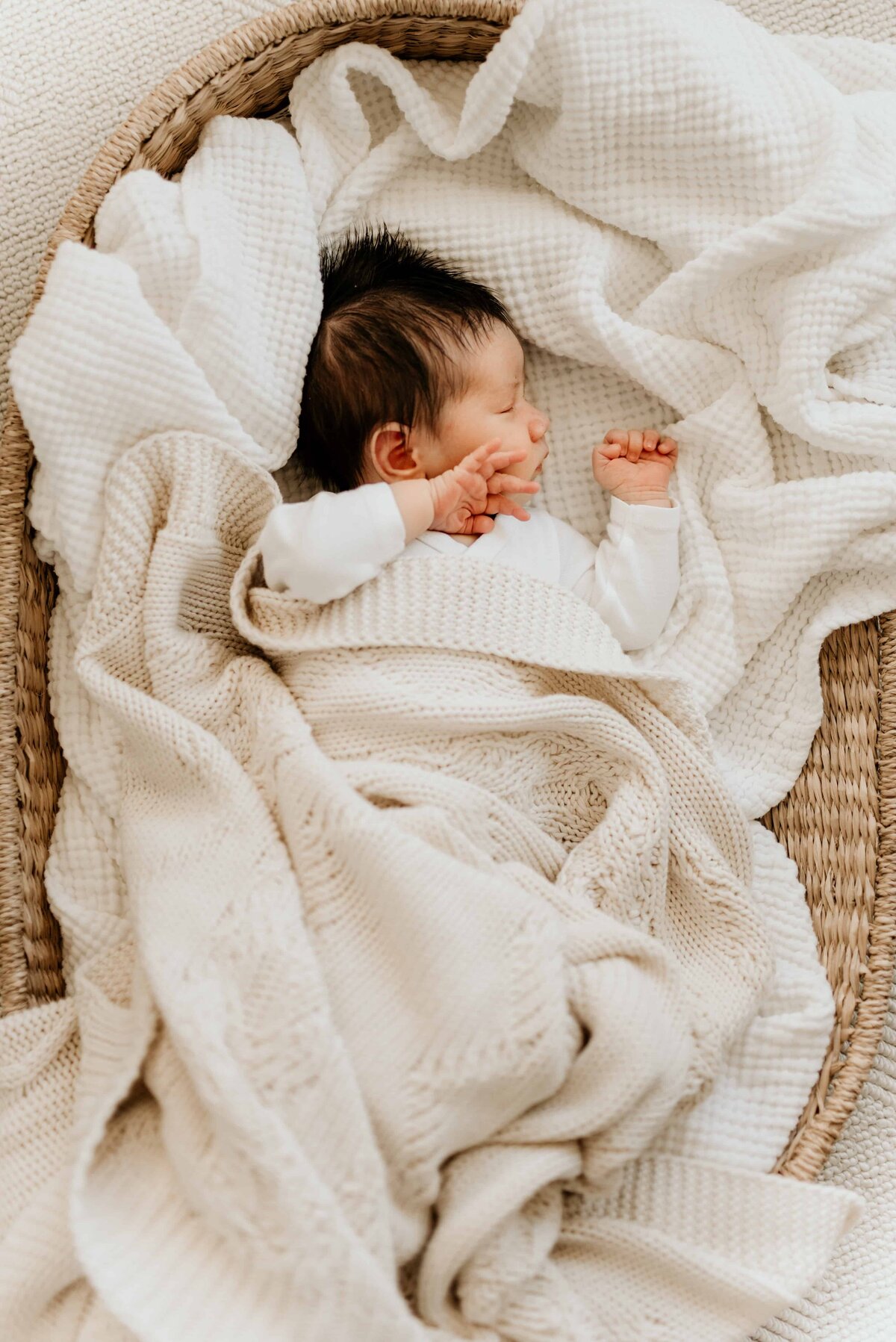 En baby ligger i en kurv og sover. Bilde tatt av Oslo nyfødtfotograf Nicola Paulukat.