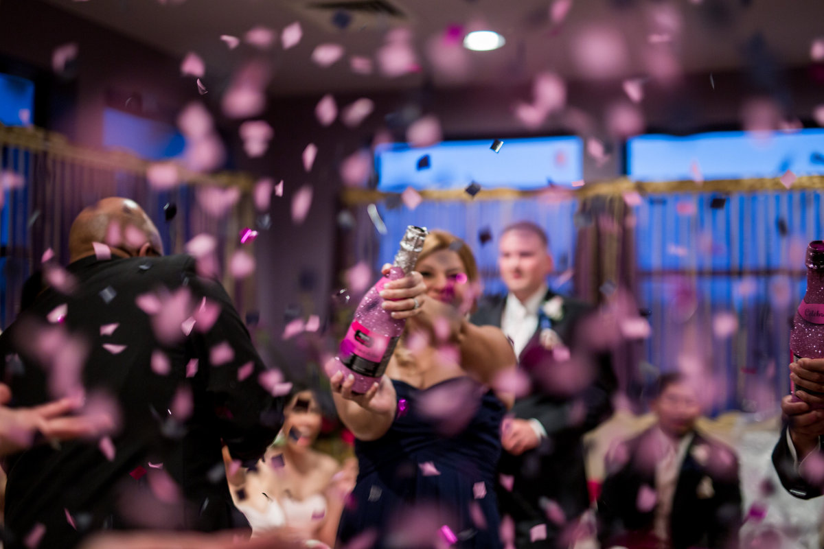 wedding party pop confetti champagne bottle after ceremony to celebrate bride and groom at Granberry Hills Event Center