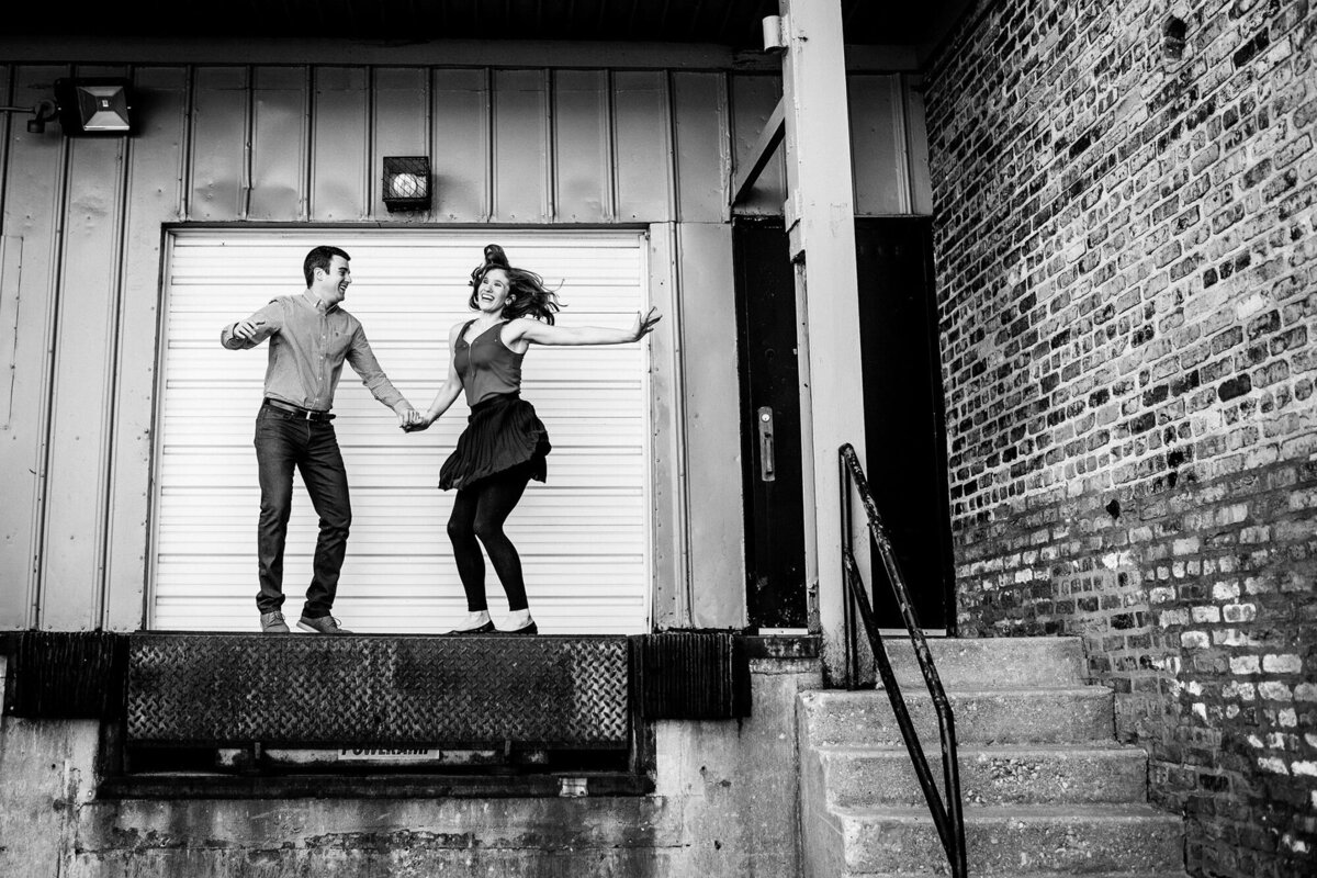 A couple jumps for joy during a West Loop engagement session.