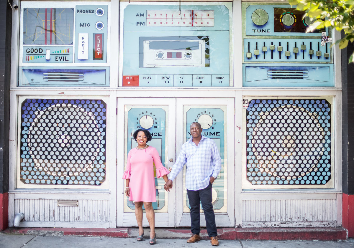 couple holding hands in front of a music store